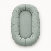Empty sage-green oval lounger with a plump padded rim, seen from above 8