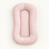 Empty soft pink lounger with a plump padded rim and smooth centre, seen from above 10