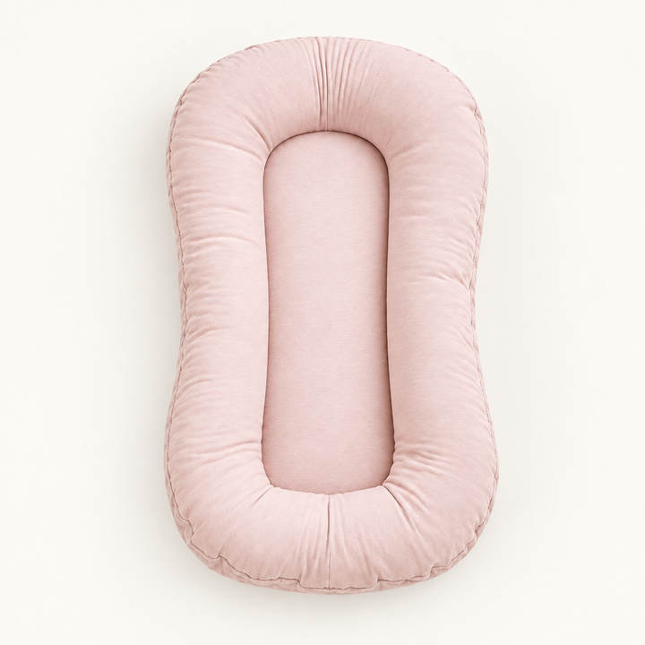 Empty soft pink lounger with a plump padded rim and smooth centre, seen from above 10