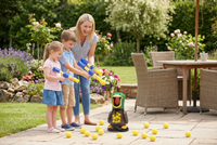 Smiling mother and two children aim foam ball launchers at the duck target on a sunny garden patio 1