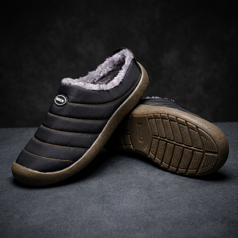 Black slipper resting on its partner, whose sole shows a grippy tread pattern, on a dark surface 19