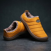Mustard yellow slippers stacked on a dark stone surface, showing the thick fleece lining and quilted stripes 20