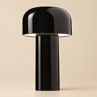 Close-up of the glossy black mushroom-shaped lamp with its wide domed shade, on a beige background 33