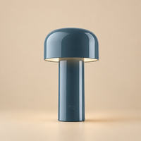 Glossy blue-grey mushroom-shaped lamp with light beneath its dome, on a cream background 30