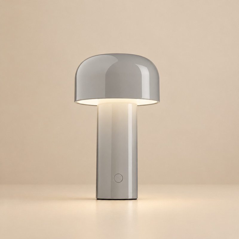Glossy light grey mushroom-shaped lamp glowing warmly on a cream backdrop, with a round button low on the stem 32
