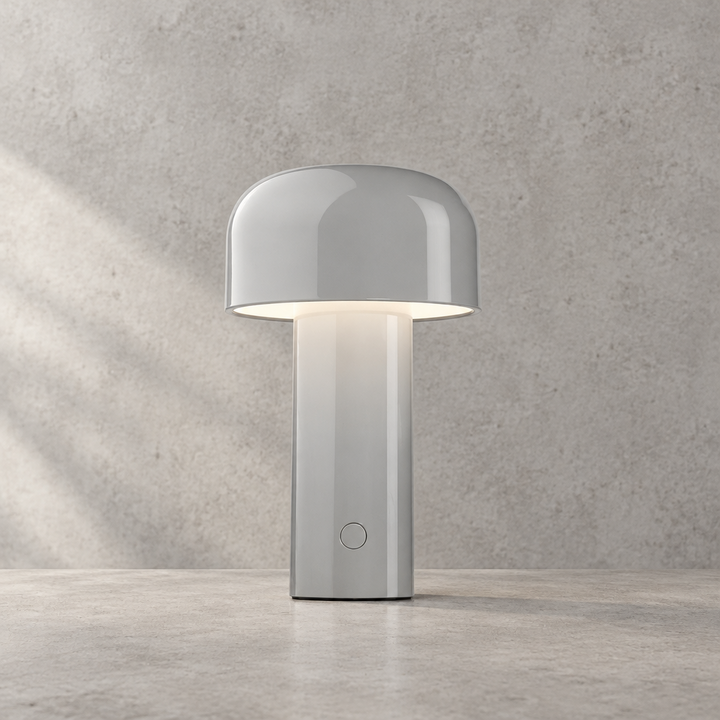 Glossy light grey lamp lit against a textured grey wall, touch button on the stem 32