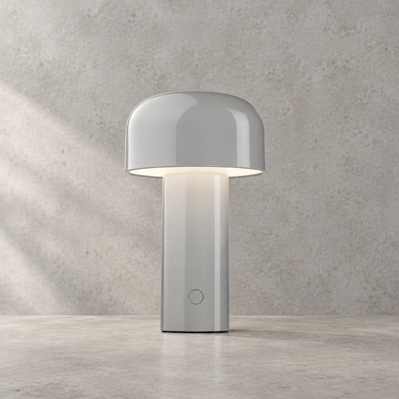 Glossy light grey lamp lit against a textured grey wall, touch button on the stem 32