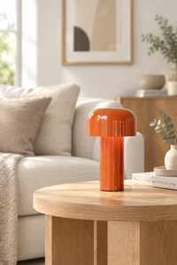 Glossy orange mushroom lamp on a round oak coffee table beside a cream sofa 1