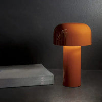 Lit burnt-orange lamp on a dark surface beside a grey hardback book 8