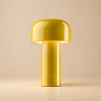Glossy yellow mushroom-shaped lamp lit up on a soft beige background, showing the round switch 31