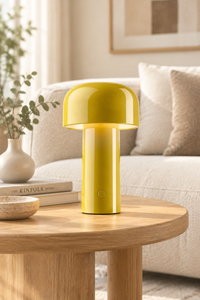 Glossy yellow mushroom lamp with a front button, on a round wooden table beside a cream sofa 29