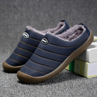 Navy blue quilted slippers with orange stitching and fleece lining, one resting on books 4