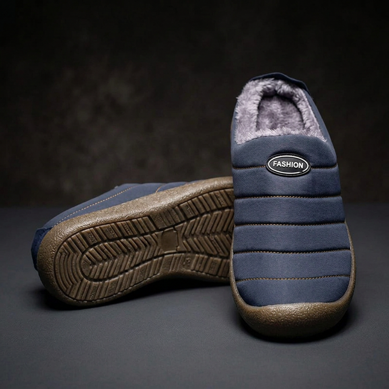 Navy blue slippers on a dark background, one upright from the front and one on its side showing the sole 18