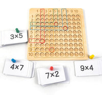 Learning game: wooden board for the 1–10 times tables with cards and dice
