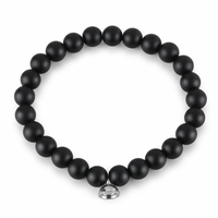 Studio shot of the matte black bead bracelet with its silver magnetic charm on plain white 5
