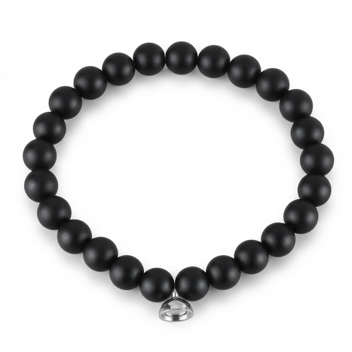 Studio shot of the matte black bead bracelet with its silver magnetic charm on plain white 5