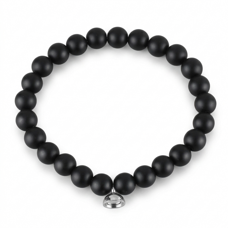 Studio shot of the matte black bead bracelet with its silver magnetic charm on plain white 5
