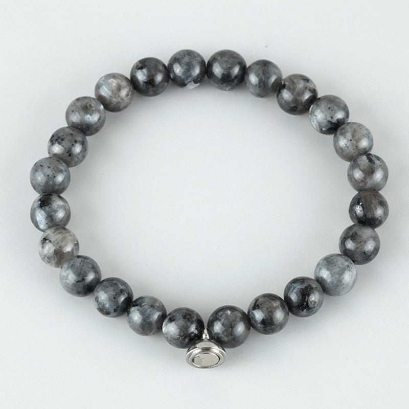 Flat lay of a bracelet of dark grey speckled round beads with a small silver clasp 4