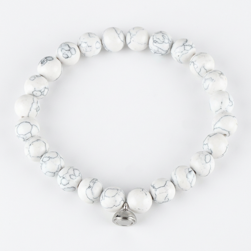 Studio shot of the white marbled bead bracelet with grey veining and a silver magnetic charm 6