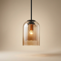 Amber layered glass pendant with a copper-toned holder and lit bulb, against a warm cream backdrop 14