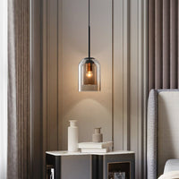 Single smoked glass pendant glowing beside a marble-topped bedside table with vases and books 3