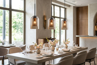 Three amber glass pendant lamps hung in a row above a set restaurant dining table 1