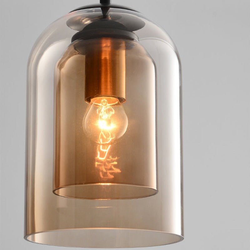 Close-up of the amber double glass shades showing a copper-toned bulb holder and lit bulb 9