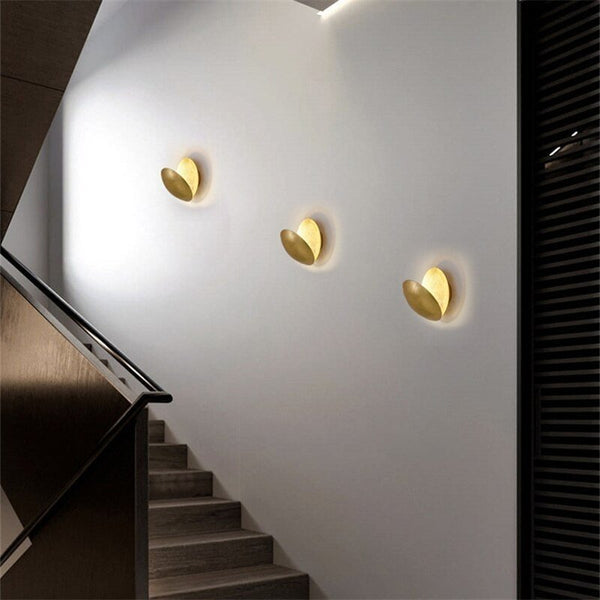 Three lamps with rotated discs, mounted in a row on a white staircase wall 8
