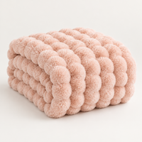 Pale pink plush blanket folded to show its thick rounded bubble texture on a light background 15