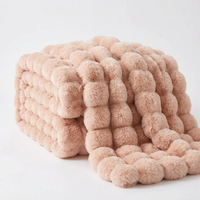 Blush pink throw with large rounded fluffy bubbles, folded and draped on a white background 17