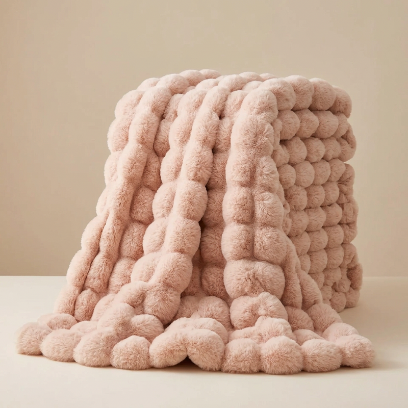 Pale pink pom-pom style fluffy blanket folded and draped, its large rounded bubbles clearly visible 15