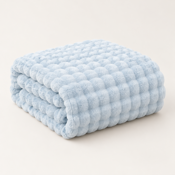 Pale blue plush blanket folded in a neat stack on a plain light background 12