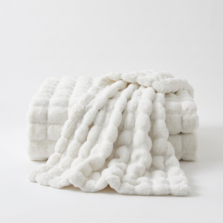 White bubble-textured throw folded with one end draped over, on a plain white background 15