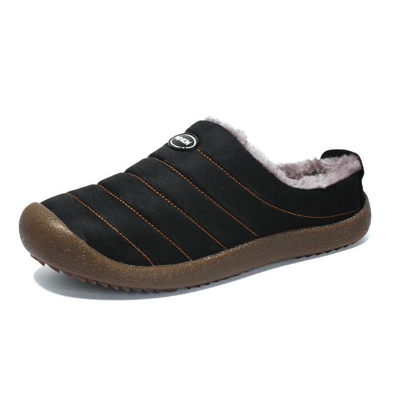 Single black quilted slipper on white background, with orange stitching and grey fleece lining 16