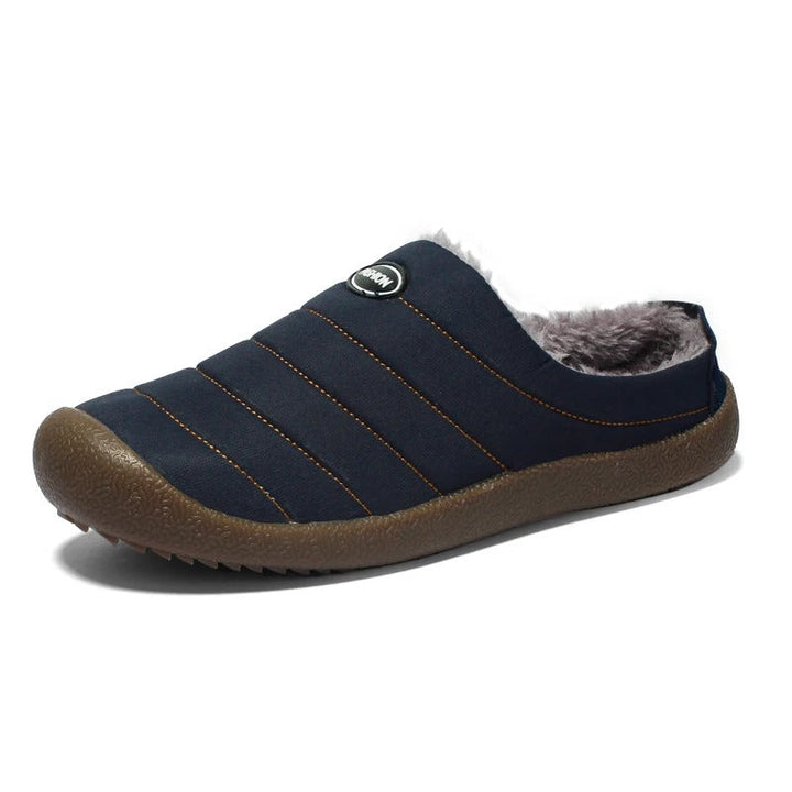 Single navy blue slipper on a white background, with orange stitching and a thick brown sole 15