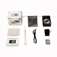 Flat lay of a black camera with its box, pouch, cloth, wrist strap, cable, plug adapter, battery and manual 8