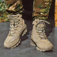 Front view of sand-coloured lace-up boots worn with camouflage trousers on a grey floor 3