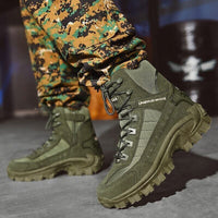 Olive green lace-up boots with chunky treads worn with digital camouflage trousers, one foot raised 4
