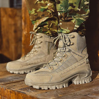 Pair of sand-coloured high-top boots worn with camouflage trousers, standing on a wooden surface 2