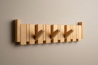 Light natural wooden rack on a grey-beige wall with three hooks folded out 14