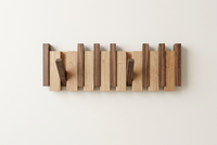 Two-tone wooden rack on a plain wall with light slats, dark slats and two hooks out 11